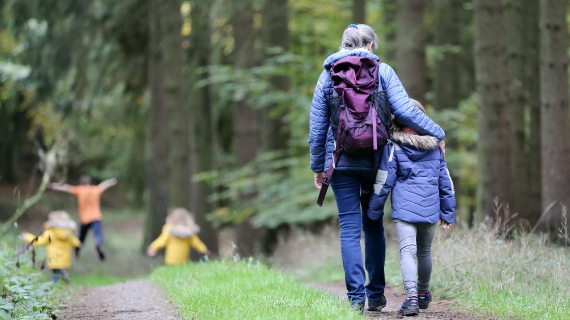 Image of family walking on a green trail